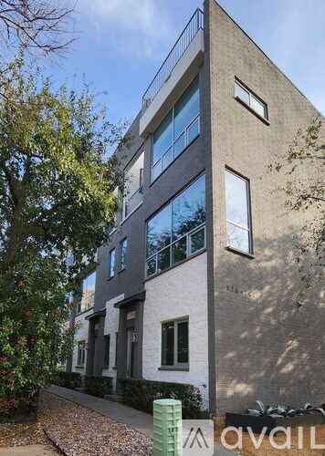 A modern building with a grey facade and large windows.