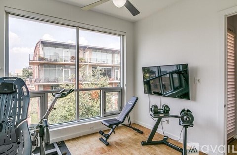 A home gym with a treadmill, bench, and weights.