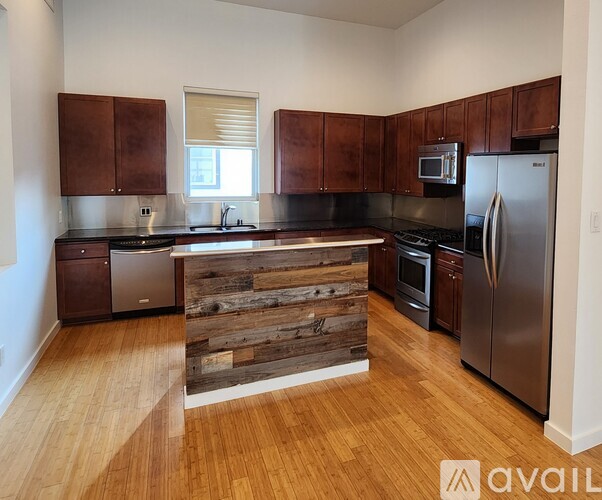 A kitchen with wooden cabinets and a wooden counter top.