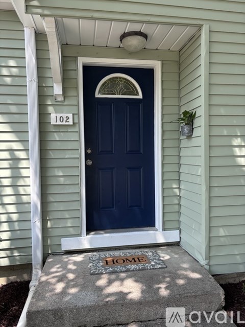 A blue door with a white frame and a number 102 on the wall above it.