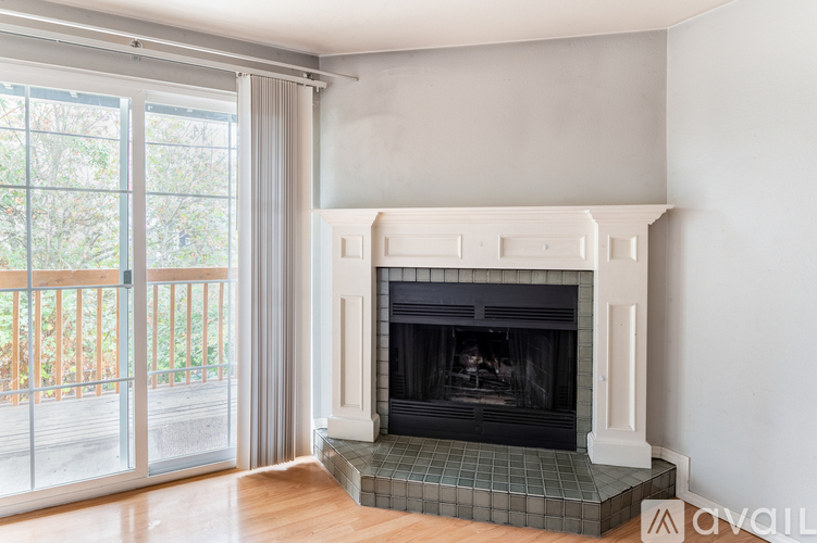 A fireplace with a tiled hearth sits in a room with a sliding glass door.