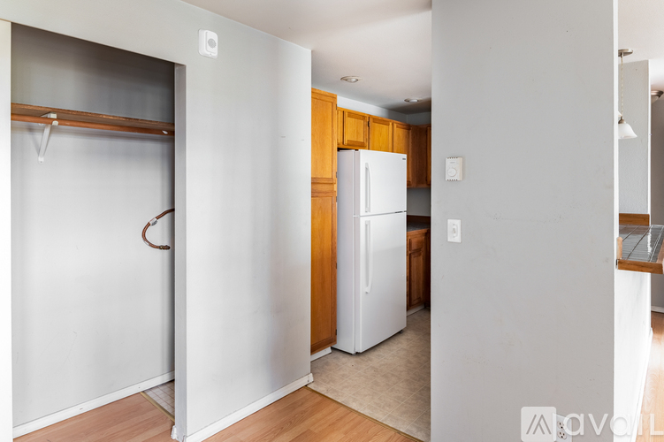 A white refrigerator in a kitchen with wooden cabinets.