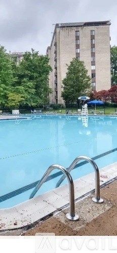A swimming pool with a ladder and a building in the background.