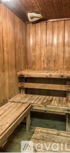 A wooden sauna with benches and a hot tub.