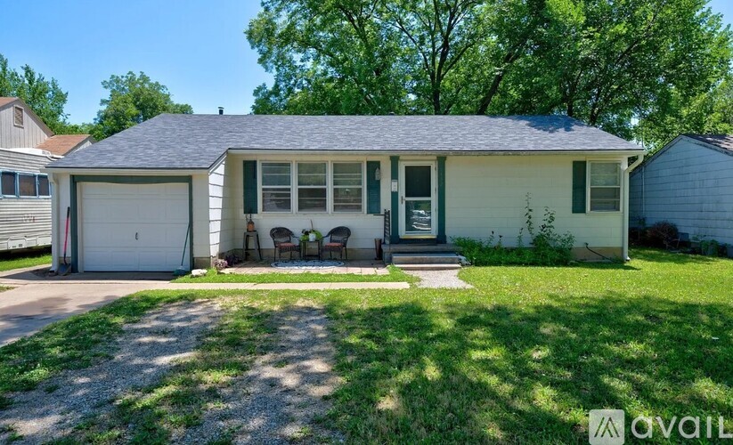 A house with a garage and a front porch with chairs.