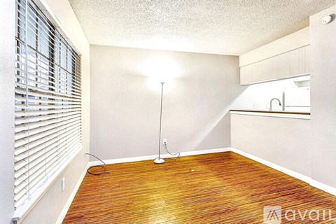 A room with wooden flooring and a single floor lamp.