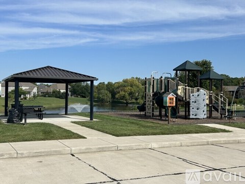 A playground with a slide, swings, and a picnic table.