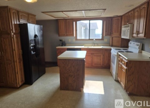 A kitchen with wooden cabinets and appliances.