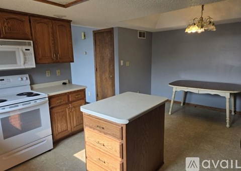 A kitchen with a white stove and wooden cabinets.