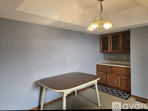 A dining room with a wooden table and chairs.