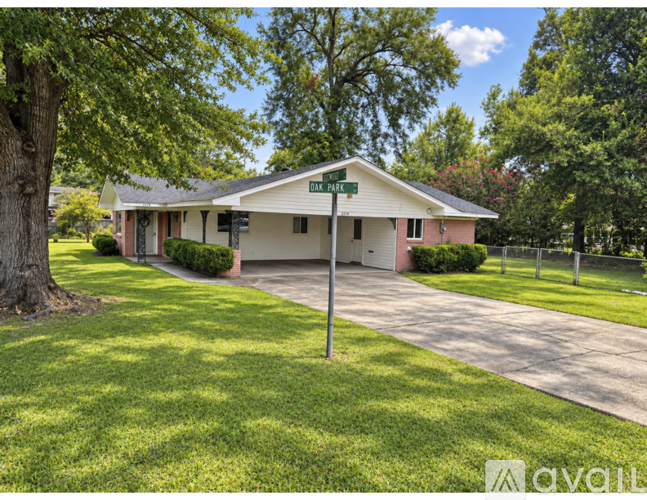 A house with a green lawn and a tree in front of it.