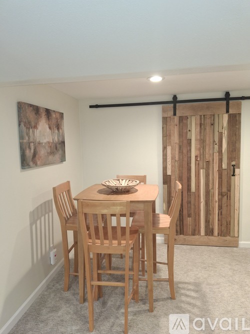 A wooden dining table with chairs and a bowl on top.