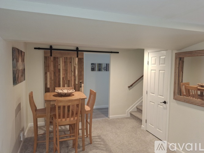 A dining room with a wooden table and chairs.