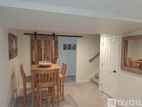 A dining room with a wooden table and chairs.