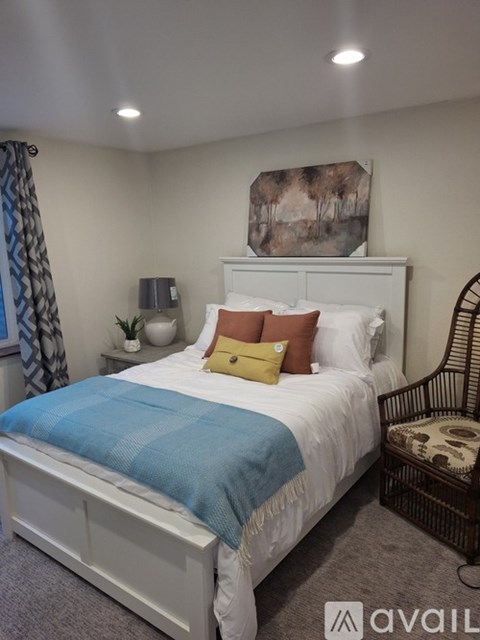 A bedroom with a white bed and a blue blanket.
