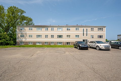 A parking lot with cars and a building in the background.