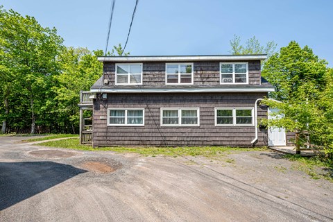 A two-story house with a driveway in front.