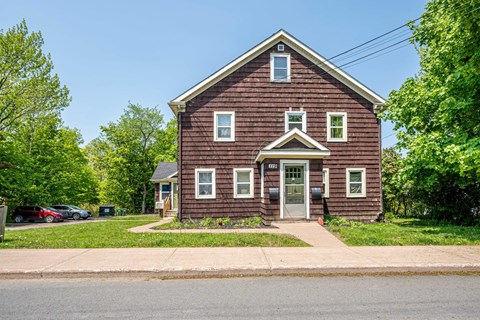 A red brick house with a white door and windows.