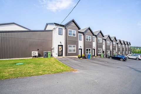 A row of houses with a car parked in front of them.