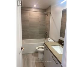 A bathroom with a toilet, sink, and shower.