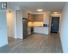 A kitchen with a refrigerator, oven, and microwave.