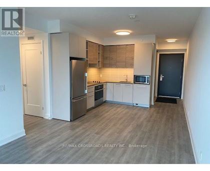 A kitchen with a refrigerator, oven, and microwave.
