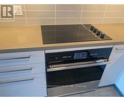 A modern kitchen with a stove top oven and a tile backsplash.