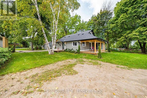 A house with a yard and trees in the background.