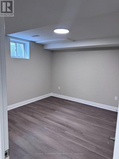 A room with light grey walls and wooden flooring.