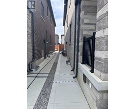 A long concrete walkway with a metal railing on the right side.