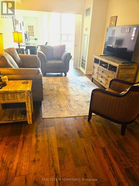 A living room with a wooden floor and a television on a cabinet.