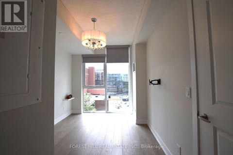 A hallway with a light fixture and a door on the right.