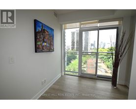 A painting of a building is hanging on a wall above a sliding glass door.