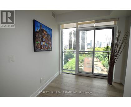A painting of a building is hanging on a wall above a sliding glass door.