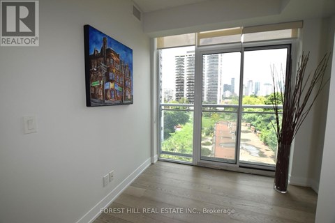 A painting of a building is hanging on a wall above a sliding glass door.