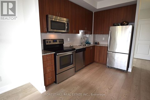 A kitchen with wooden cabinets and stainless steel appliances.