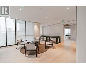 A modern office space with a glass wall and a view of the city.