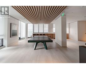 A modern room with a long table and a green bench.