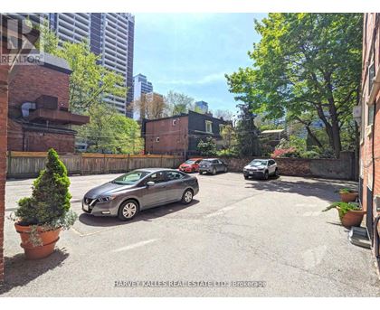 A parking lot with cars and a building in the background.