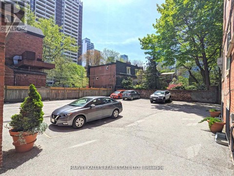 A parking lot with cars and a building in the background.
