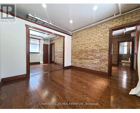 A room with wooden floors and a brick wall.