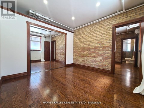 A room with wooden floors and a brick wall.