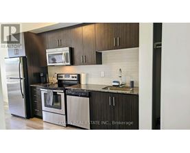 A modern kitchen with dark wood cabinets and stainless steel appliances.