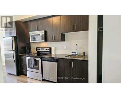 A modern kitchen with dark wood cabinets and stainless steel appliances.