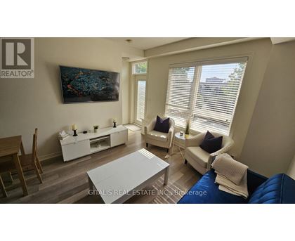 A living room with a blue couch and a painting on the wall.