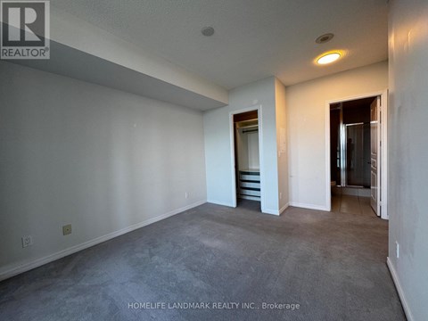 A spacious room with a staircase leading to another room.