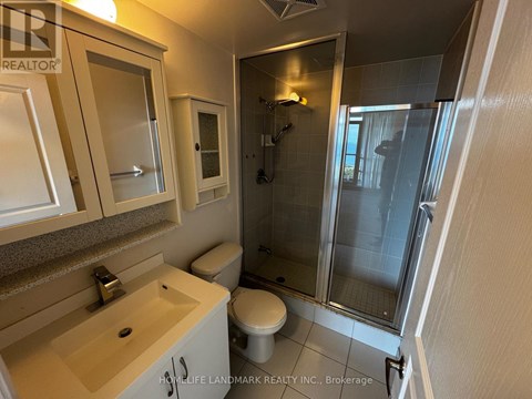 A bathroom with a toilet, sink, and shower.