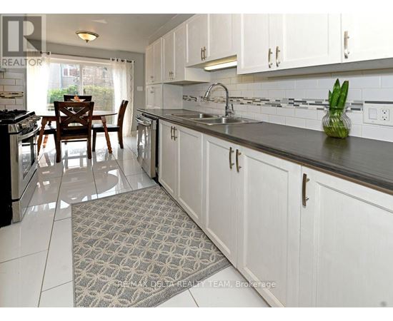 A kitchen with white cabinets and a black countertop.