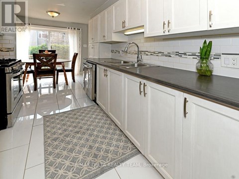 A kitchen with white cabinets and a black countertop.