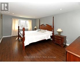 A bedroom with a large bed and wooden floors.